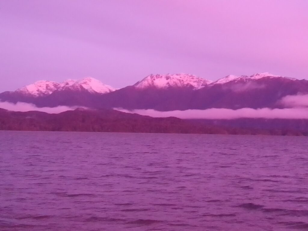 Lakeside view of the Fiordland Mountains at sunrise. Te Anau, New Zealand. Photo by Brandon Kojic.